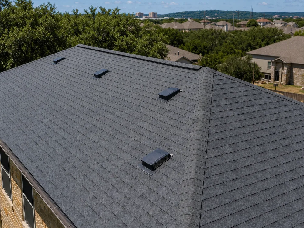 Completed asphalt shingle roof with straight courses, a clean ridge cap, and properly placed vents
